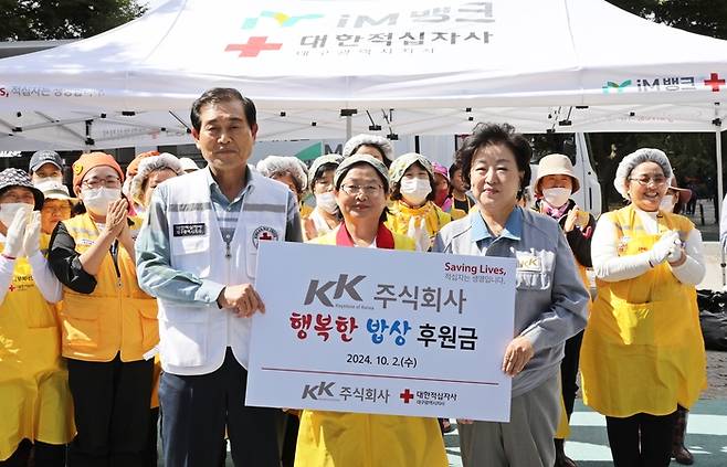 박윤경 케이케이 대표(왼쪽 셋째)가 대한적십자사에 무료급식 후원금을 전달하고 기념 촬영을 하고 있다. 지난해 10월 2일 박 대표는 대구 달서구 두류공원에서 취약계층 노인 1000여 명을 대상으로 한 무료급식 봉사활동에 참여했다. 사진 왼쪽부터 박명수 적십자 대구지사 회장, 강은숙 적십자봉사회 달서구협의회 부회장, 박 대표. [적십자]