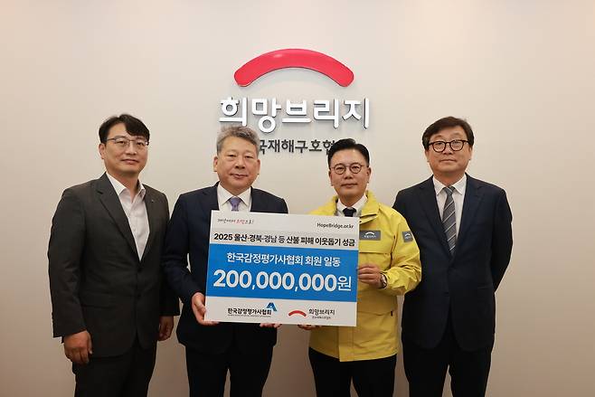 양길수(왼쪽에서 두번째) 한국감정평가사협회장과 협회 종별협의회 의장단이 산불 피해복구 성금 2억원을 전달하고 있다. [한국감정평가사협회 제공]