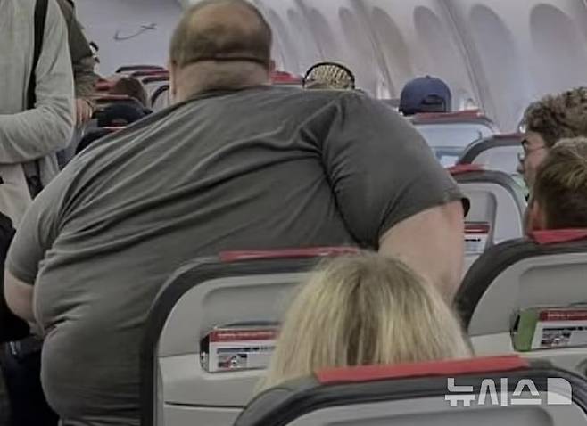 [서울=뉴시스]비행기에서 한 과체중 탑승객의 모습을 담은 사진이 온라인에 퍼지면서 항공사 규정을 변경하라는 누리꾼들의 갑론을박이 펼쳐졌다.(사진=데일리메일)