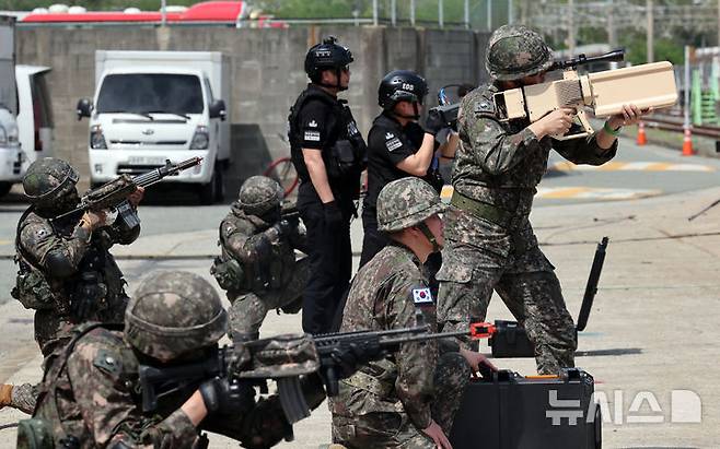 [부산=뉴시스] 하경민 기자 = 2025년 충무훈련의 하나로 '도시철도 피해복구 종합 실제훈련'이 열린 23일 부산 금정구 도시철도 1호선 노포차량정비창에서 군 장병 등이 재밍건과 개인화기를 이용해 드론 테러에 대응하고 있다.  전시 적 공격으로 인한 도시철도 시설피해 발생에 대비한 민·관·군·경·소방 합동훈련에는 53사단 부산여단과 부산교통공사, 금정구청, 금정소방서, 보건소, 부산항만공사, 금정결찰서 등 7개 기관 200여 명이 참가했다. 2025.04.23. yulnetphoto@newsis.com