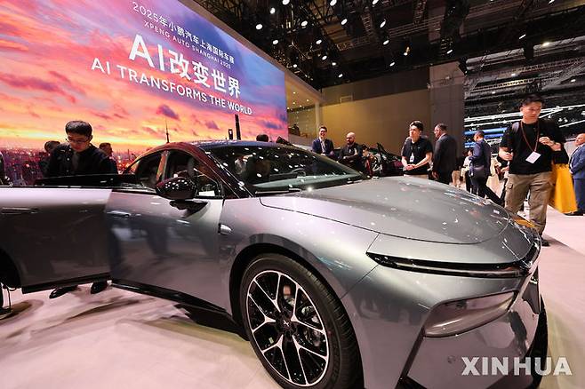 [상하이=신화/뉴시스] 23일 개막한 중국 상하이 모터쇼에서 관람객들이 전시된 차를 문을 열어 살펴보고 있다. 뒷 배경에 인공지능(AI)이 세상을 바꾼다는 문구가 보인다.2024.04.24.