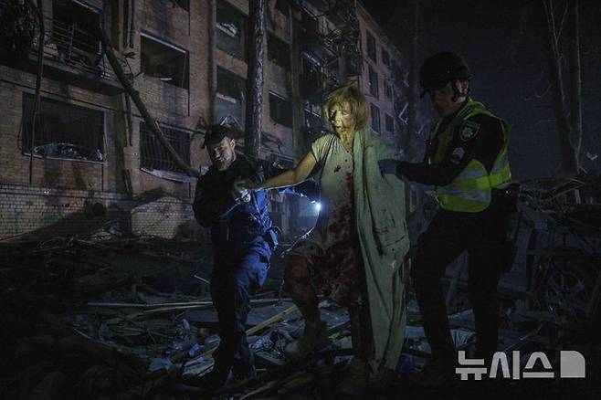 [키이우=AP/뉴시스] 24일(현지 시간) 우크라이나 키이우의 주택가에서 러시아의 공습으로 부상한 여성이 경찰의 도움을 받아 대피하고 있다. 비탈리 클리치코 키이우 시장은 러시아의 대규모 공격으로 최소 2명이 숨지고 6명의 어린이와 임산부 등 54명이 부상했다고 밝혔다. 2025.04.24.