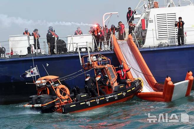 [부산=뉴시스] 하경민 기자 = 항공기 해상 불시착 상황을 가정한 수난대비 합동 구조훈련이 열린 24일 부산 강서구 진우도 인근 해상에 불시착한 모의항공기(500t급 경비함)에서 해경이 비상탈출하는 승객들을 구조하고 있다. 이날 훈련에는 남해지방해양경찰청, 창원해양경찰서 등 13개 유관기관·단체에서 총 14척의 선박과 헬기 1기가 동원됐다. 2025.04.24. yulnetphoto@newsis.com