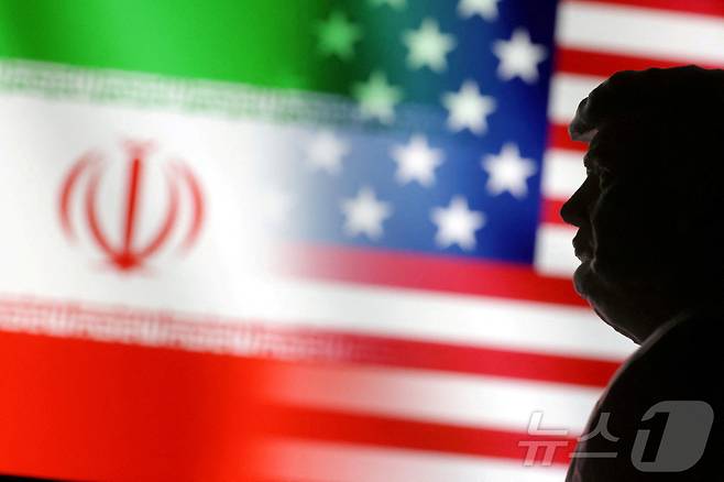 도널드 트럼프 미국 대통령의 뒤로 미국과 이란 국기가 나란히 펼쳐진 모습. 2025.01.15 ⓒ 로이터=뉴스1 ⓒ News1 김지완 기자