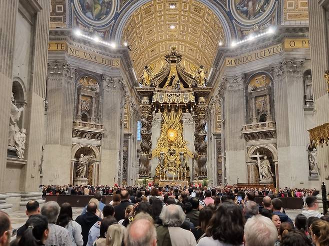 24일 저녁 성 베드로 대성전 안의 모습. 프란치스코 교황을 조문하기 위해 몰려든 사람들이 줄을 서 있다. 높이 약 30m의 거대한 발다키노(天蓋) 앞에 교황의 관이 놓여 있다. /바티칸=정철환 특파원