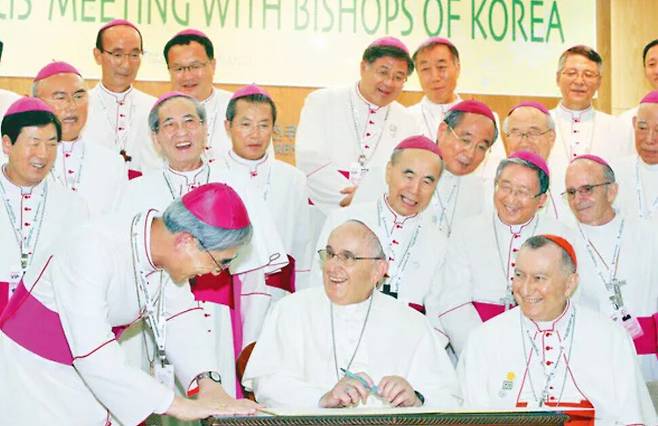 2014년 8월 서울 광진구 한국천주교중앙협의회를 찾은 프란치스코 교황이 방명록을 쓰다가 교황방한준비위원장인 강우일 한국천주교주교회의 의장과 담소하고 있다. 신소영 기자 viator@hani.co.kr