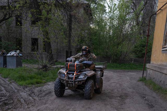 우크라이나 도네츠크주의 코스티안티니우카에서 우크라이나 군인이 전투용 오토바이를 타고 있다. 코스티안티니우카=AP 연합뉴스