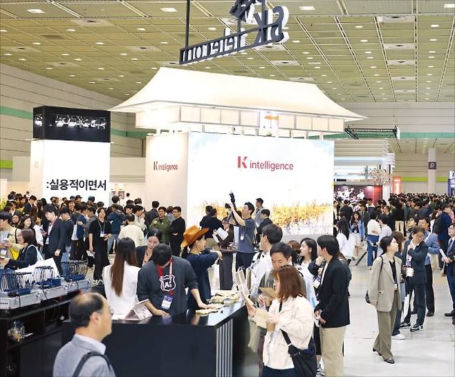 < 체험관 북적 > ‘월드IT쇼 2025’에서 관람객들이 SK텔레콤과 KT 전시관을 둘러보고 있다.  /강은구 기자