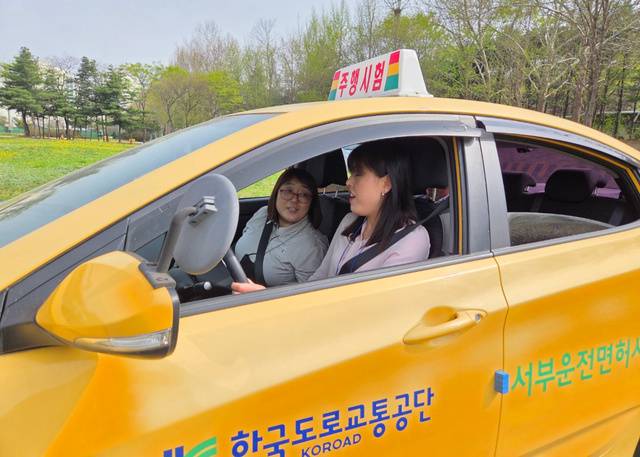 중증 시각장애인 한솔씨가 서울 마포구 서부운전면허시험장에서 한국도로교통공단 직원의 도움을 받아 운전을 하고 있다.