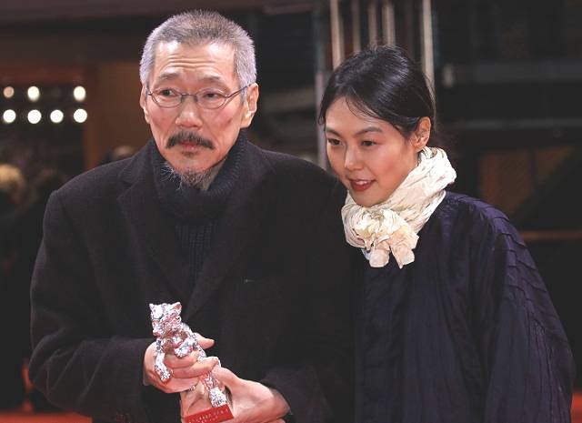 홍상수 감독이 2022년 2월 16일(현지시간) 제72회 베를린 국제영화제 시상식에서 영화 ‘소설가의 영화’로 은곰상 심사위원대상을 받고 연인인 김민희와 함께 기념촬영을 하고 있다. AP뉴시스