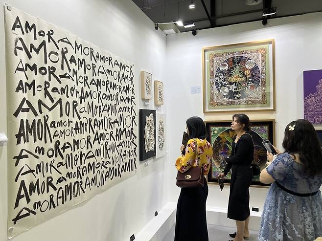 ‘AMOR(사랑)’으로 캔버스를 잔뜩 채운 적힌 김도임 화백의 작품을 관람객이 감상하고 있다. 코리안아트패스의 일환으로 월드아트두바이에 참여한 그는 이번 전시회에 붓글씨를 활용한 다양한 켈라그래피 작품을 선보였다.