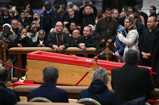 목관에 안치된 프란치스코 교황에게 조문객들이 경의를 표하고 있는 모습. [사진 = AFP 연합뉴스]