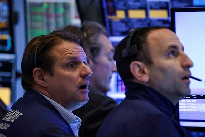 24일 뉴욕거래소(NYSE)에서 트레이더들이 화면을 지켜보고 있다. [로이터]