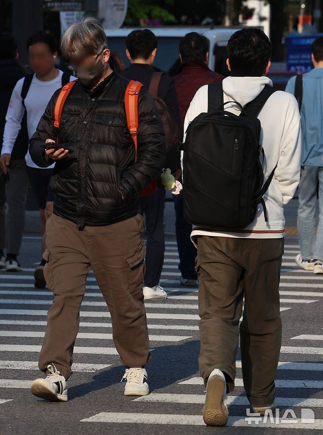 [서울=뉴시스] 이영환 기자 = 아침 기온이 떨어지며 비교적 쌀쌀한 날씨를 보인 25일 오전 서울 종로구 광화문네거리에서 외투를 걸친 시민들이 이동하고 있다. 2025.04.25. 20hwan@newsis.com