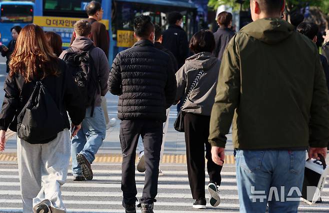 [서울=뉴시스] 이영환 기자 = 아침 기온이 떨어지며 비교적 쌀쌀한 날씨를 보인 25일 오전 서울 종로구 광화문네거리에서 외투를 걸친 시민들이 이동하고 있다. 2025.04.25. 20hwan@newsis.com