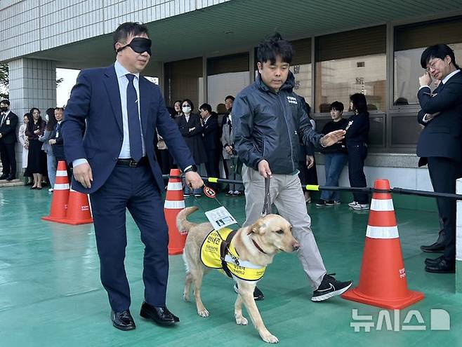 [서울=뉴시스] 이지민 수습 기자 = 25일 오전 서울남부지법에서 진행된 '장애인의 날' 행사에 법원 직원들이 참여해 안내견 체험을 하고 있다. 2025.04.25. ezmin@newsis.com