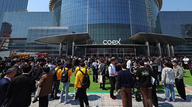 25일 건물내 입점한 식당에서 화재가 발생한 서울 강남구 코엑스 앞에 긴급 대피한 시민들이 모여 있다.