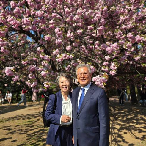 문재인 전 대통령이 김정숙 여사 25일 국회 사랑재 인근 겹벚나무 앞에서 환하게 웃고 있다. (사진=문재인 전 대통령 SNS)