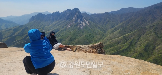 ▲ 화암사 신선대 정상에 오른 한 연인이 울산바위를 배경으로 서로 기념사진을 찍고 있다.