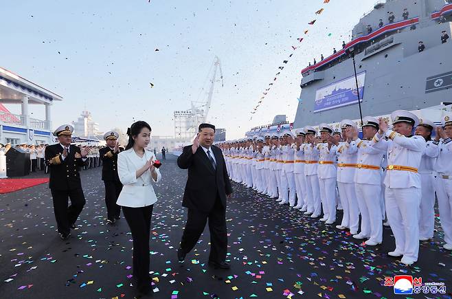 Kim and Ju-ae walk past rows of applauding naval officers following the launch ceremony at Nampho Shipyard on Friday. (Yonhap)
