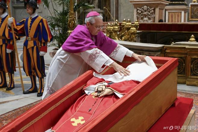 [바티칸=AP/뉴시스] 교황전례원장 디에고 조반니 라벨리 대주교가 25일(현지 시간) 바티칸 성 베드로 대성당에서 고(故) 프란치스코 교황의 관을 닫기 전 그의 얼굴을 비단 천으로 덮고 있다. 2025.04.26. /사진=민경찬