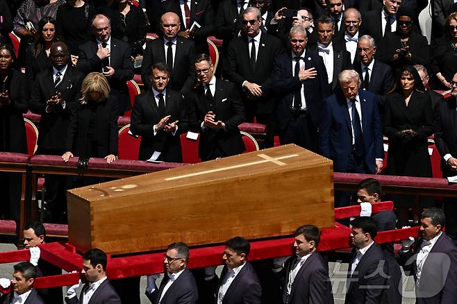 도널드 트럼프 미국 대통령과 부인 멜라니아 여사가 26일 (현지시간) 바티칸의 성 베드로 광장에서 열린 프란치스코 교황의 장례 미사 중 관이 옮겨 지는 모습을 지켜 보고 있다. 2025.04,27 ⓒ 로이터=뉴스1