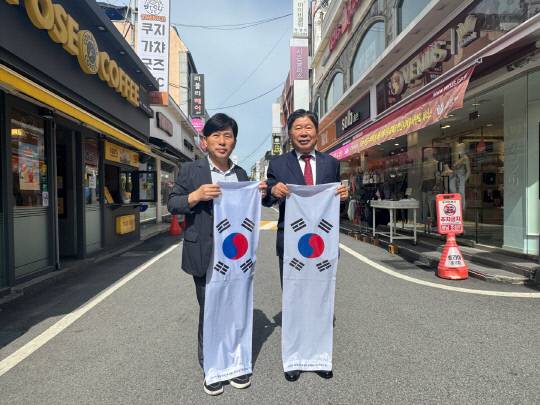 홍성역사인물축제 홍보를 위해 최건환 홍주문화관광재단 대표이사(오른쪽)과 김병태 명동상가상인회 회장이 태극기 거리퍼레이드를 펼치고 있다. 홍성군 제공.