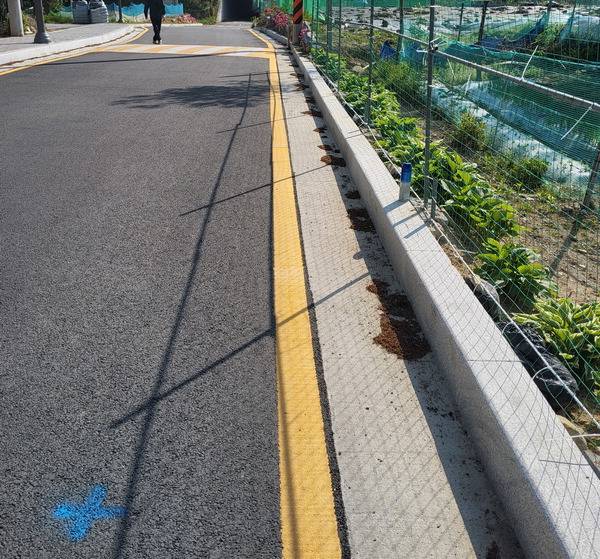 부산 금정구 오륜동 수원지마을 진입도로. 금정구는 공사 과정에서 파란색 표시부터 약 10ｍ 구간의 사유지를 침범했다.  독자제공