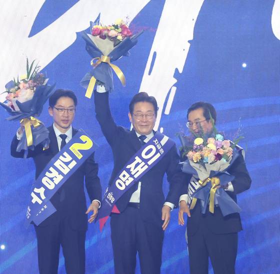 Presidential primary candidates of the Democratic Party pose for photos after the final vote is counted on April 27 in Kintex, Gyeonggi. From left are Kim Kyoung-soo, Lee Jae-myung and Kim Dong-yeon. [YONHAP]