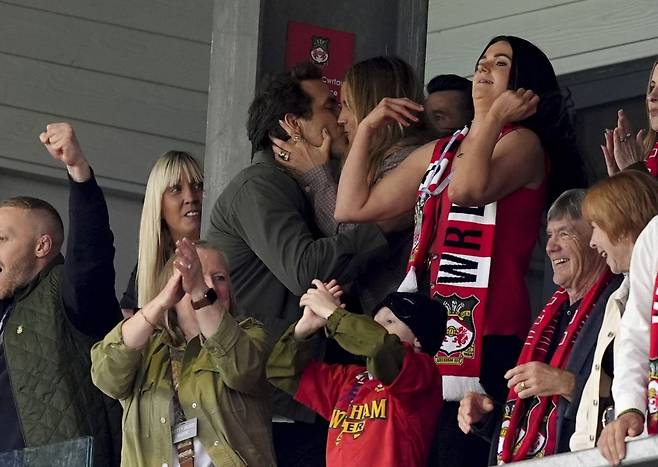 렉섬의 공동 구단주 라이언 레이놀즈(왼쪽)가 27일(한국시간) 찰턴 애틀레틱과의 경기에서 선제골이 나온 뒤 아내 블레이크 라이블리와 입맞춤을 하고 있다. 연합뉴스