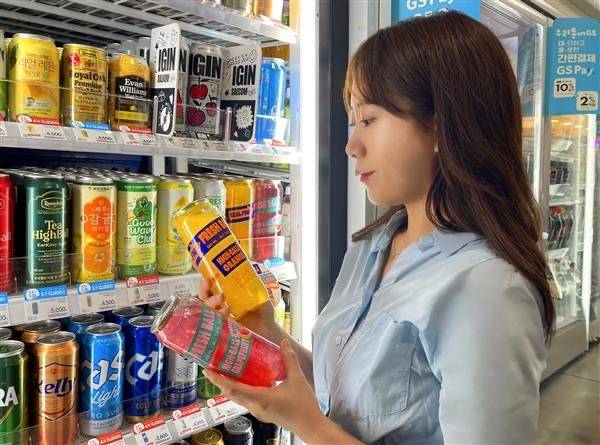20대 여성이 GS25 하이볼 제품을 살펴보고 있다. GS25.