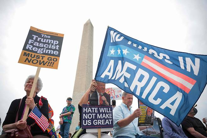 4월19일 반(反)트럼프 시위 참가자들이 워싱턴DC에서 피켓을 들고 구호를 외치고 있다. ⓒAFP 연합