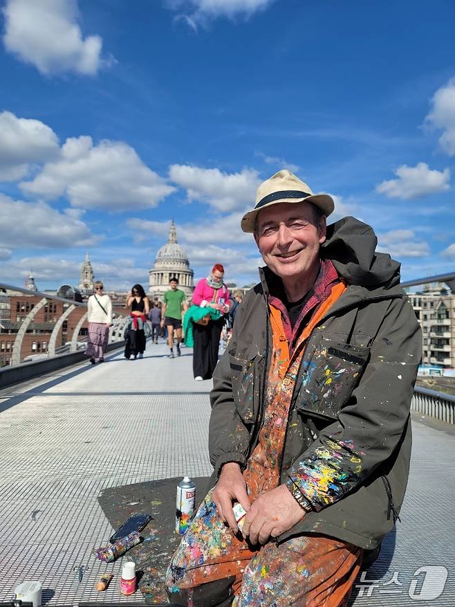 영국의 유명 환경 예술가 벤 윌슨(Ben Wilson)이 밀레니엄 브리지 바닥 위에서 아크릴 물감을 손에 쥔 채 환하게 웃고 있다. @조아현