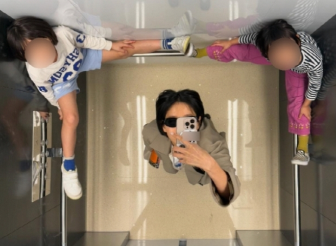 김나영이 두 아들이 엘리베이터 손잡이 위에 올라가 있는 모습이 일부 네티즌의 비판을 받았다.  이 사진은 삭제된 상태다. 사진 | 김나영 SNS