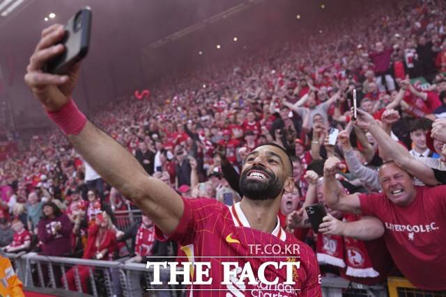 리버풀 우승의 '일등공신' 모하메드 살라가 28일 토트넘과 2024~2025 EPL 34라운드 홈 경기에서 후반 18분 추가골을 넣은 뒤 팬의 휴대폰으로 셀카를 찍는 세리머니를 펼치고 있다./리버풀=AP.뉴시스