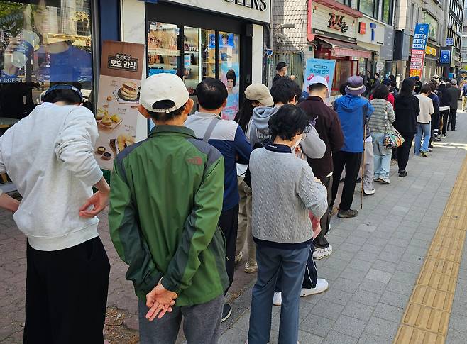 지난 26일 서울 시내 한 SK텔레콤 대리점 앞에 유심(USIM)을 교체하려는 가입자들이 길게 줄을 서서 기다리고 있다. SK텔레콤은 28일부터 유심을 무료로 교체한다고 발표했지만, 불안감이 커진 가입자들은 주말 내내 유심을 교체하기 위해 매장마다 몰렸다./연합뉴스