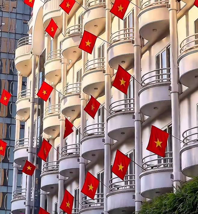 베트남 통일절 50주년 행사를 보기 위해 몰린 사람들. 도심 건물들에는 베트남 국기인 금성홍기가 내걸렸다. /온라인캡처