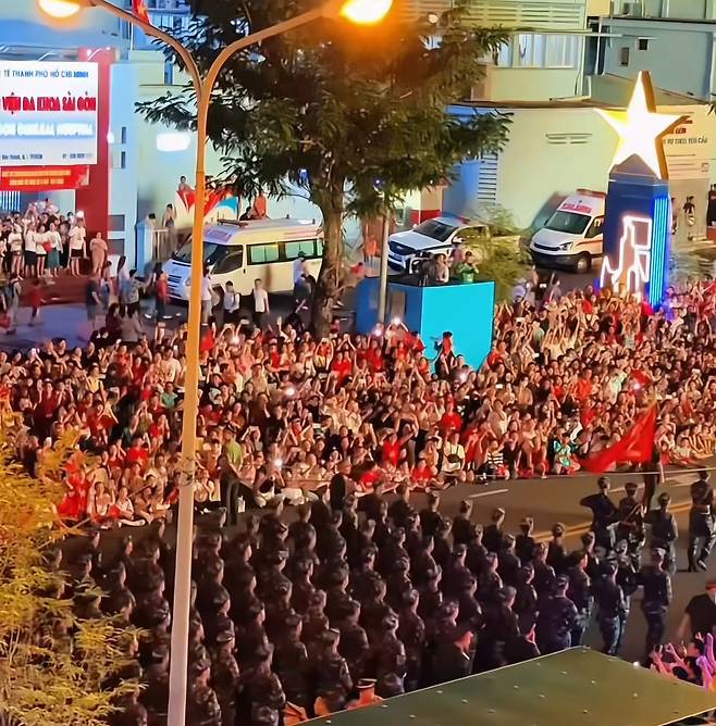 베트남 통일절 50주년 행사를 보기 위해 몰린 사람들. 도심 건물들에는 베트남 국기인 금성홍기가 내걸렸다. /온라인캡처