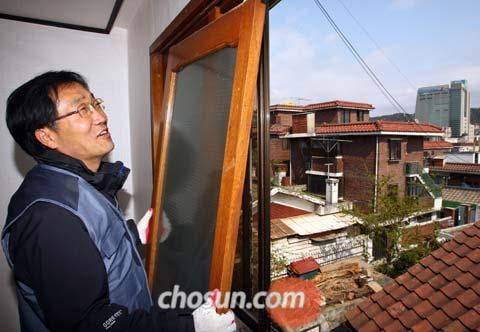사회적 기업 ‘나눔하우징’을 이끌었던 송경용 신부가 서울 은평구의 한 연립주택에서 도배를 새로 하고 창틀을 걸고 있다. 빈민운동의 대부인 그는 협동조합, 사회연대기금을 만들어 사회적 경제 운동을 펼쳐왔다. /조선일보DB