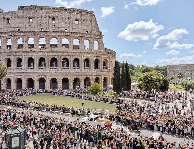 프란치스코 교황의 장례 미사가 지난 26일 바티칸 성 베드로 광장에서 끝난 뒤 로마 시내 콜로세움 앞을 지나는 운구 행렬. 교황이 생전 탑승했던 '포프 모빌(Popemobile·교황의 차)'이 교황을 운구하고 있다. 이날 로마 시민 약 40만여 명이 거리에 나와 교황을 배웅했다. 교황은 유언대로 산타 마리아 마조레 대성당에 안장됐다. /AP 연합뉴스