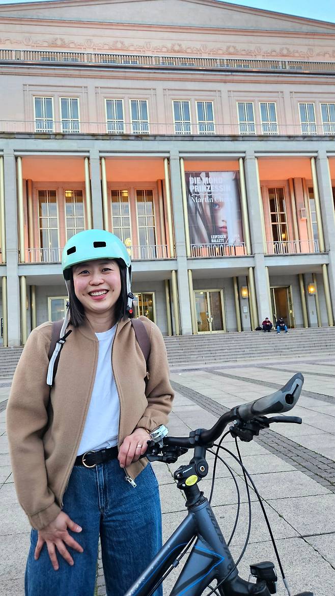 20일 저녁 '마탄의 사수' 지휘를 마치고 나온 양유라. 극장 앞 현수막은 다음 날 지휘할 발레 '달의 공주'로 바뀌었다. 자전거로 출퇴근한다고 했다. /김기철기자