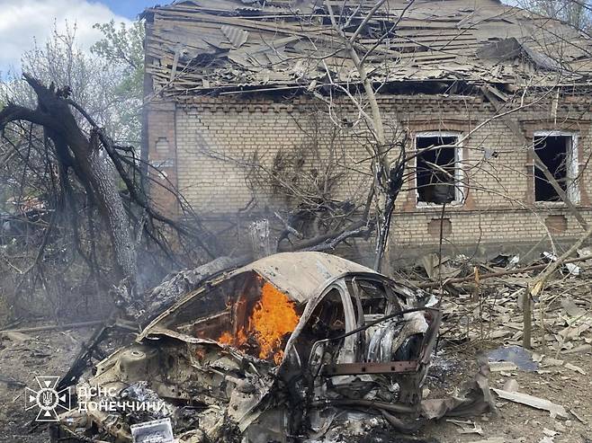 우크라이나 도네츠크 지역에서 28일 러시아군의 공습으로 파손된 한 주택 앞에서 자동차가 불타고 있다. 러시아는 28일 전승절을 기념해 5월 8~10일 우크라이나와의 휴전을 선언했다. [도네츠크(우크라이나)=AP/뉴시스]