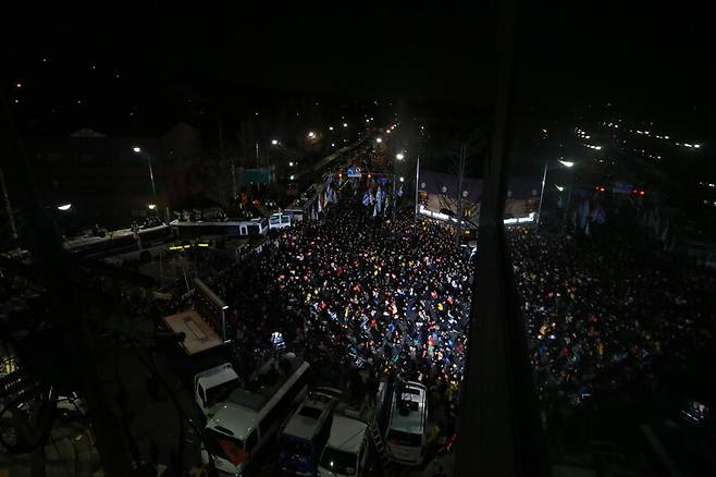 ‘박근혜 즉각 퇴진 6차 촛불집회’가 열린 2016년 12월3일 저녁 서울 종로구 청운효자동주민센터 앞 신교동교차로에 모인 시민들이 저녁 7시가 되자 ‘저항의 1분 소등’에 동참해 촛불을 모두 끈 채 앉아 있는 동안 생방송 중계를 위한 조명이 들어와 있다. 김정효 기자 hyopd@hani.co.kr