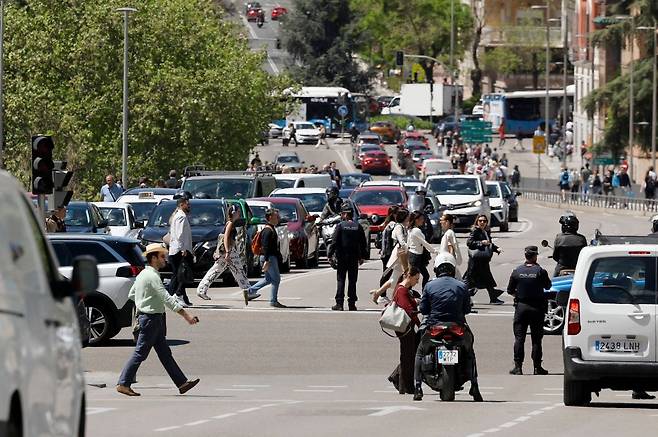 스페인 마드리드에서 대규모 정전으로 인해 신호등이 꺼진 상태에서 경찰관들이 교통을 통제하고 있는 모습. AFP연합뉴스
