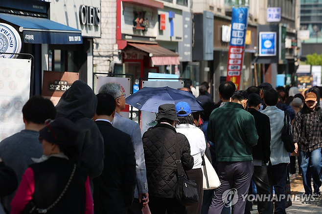 SK텔레콤이 유심 고객정보 해킹 사고로 관련 유심 무료 교체 서비스에 나선 28일 서울 시내 한 SKT T월드 매장 앞에 유심을 교체하려는 고객들이 영업 전부터 줄을 서 있다. [연합뉴스]