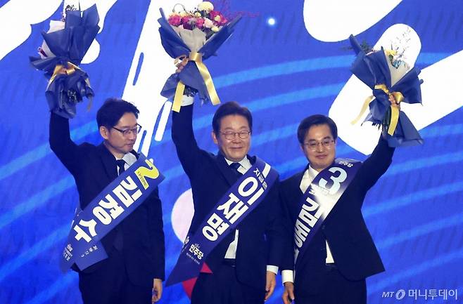 [고양=뉴시스] 조성우 기자 = 더불어민주당 제21대 대통령 선거 후보에 선출된 이재명(가운데) 후보가 27일 경기도 고양시 킨텍스에서 열린 제21대 대통령 선거 후보자 선출을 위한 수도권·강원·제주 합동연설회에서 김경수, 김동연 후보와 꽃다발을 들고 인사하고 있다. 2025.04.27. xconfind@newsis.com /사진=조성우