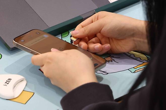 가입자 유심(USIM) 정보를 탈취당한 SK텔레콤이 유심 무료교체 서비스를 시작한 28일 서울 시내 한 SKT 대리점에서 직원이 유심 교체를 하고 있다. [연합]