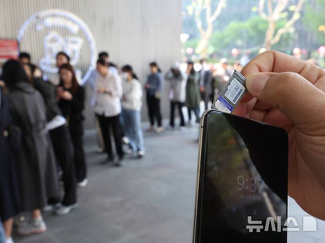 [서울=뉴시스] 조수정 기자 = 28일 오전 서울 시내 한 SKT 대리점에서 한 이용자가 유심을 교체하고 있다. 왼쪽은 기다리는 이용자들.해킹사고가 발생한 SKT는 사이버침해 피해를 막기 위해 28일 오전 10시부터 전국 2600여곳의 T월드 매장에서 희망 고객 대상 유심교체를 무료로 진행하기로 했다. 2025.04.28. chocrystal@newsis.com