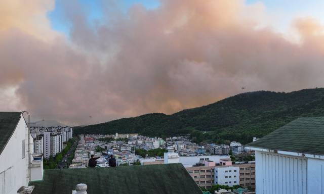 28일 오후 2시1분께 대구 북구 노곡동 함지산에서 발생한 산불이 확산하고 있는 가운데 서변동 한 아파트 옥상에서 주민들이 산불 상황을 지켜보고 있다. 연합뉴스