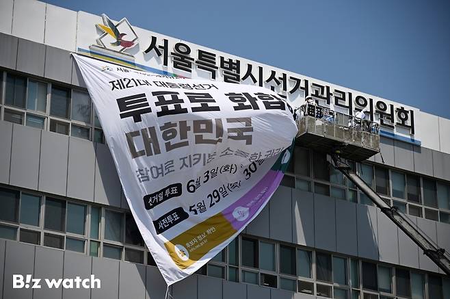 29일 오후 서울 종로구 창경궁로 서울시선거관리위원회 외벽에 관계자들이 제21대 대통령 선거 대형 홍보 현수막을 게시하고 있다./사진=이명근 기자 qwe123@
